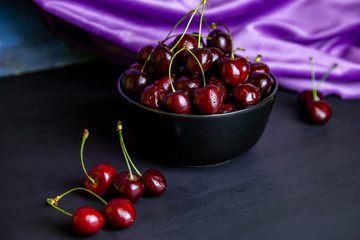 cherries in black containers on the table
