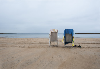 Empty hammocks on the beach with colorful towels