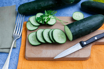 Pepino fresco troceado sobre una tabla de cortar