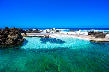 Natural volcanic swimming lagoon pools at Porto Moniz, travel destination for vacation, Madeira island, Portugal