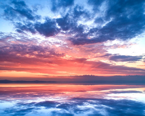 Naklejka premium Amazing sunset and sky reflection in the water.