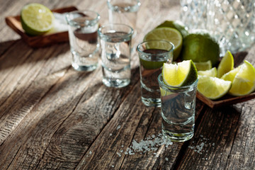 Tequila with  salt and lime on a old wooden background.