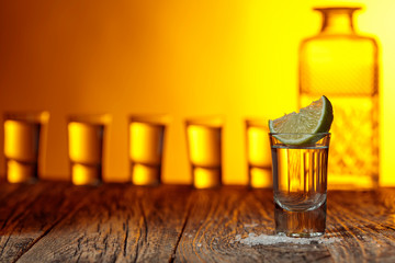Tequila with  salt and lime on a old wooden background.