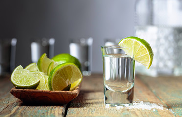 Tequila with  salt and lime on a old wooden background.