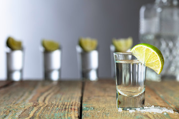 Tequila with  salt and lime on a old wooden background.