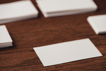 selective focus of white blank business cards on brown wooden surface