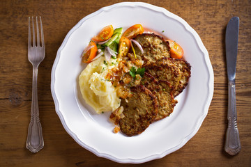 Chicken liver pancakes with mashed potato and vegetables on white plate. Liver side dish