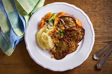 Chicken liver pancakes with mashed potato and vegetables on white plate. Liver side dish
