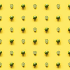 Seamleas limes pattern on punchy yellow background. Creative food concept. Flat lay. Top view.