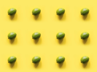 Seamleas limes pattern on punchy yellow background. Creative food concept. Flat lay. Top view.