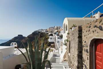 View of traditional white houses and churches with blue domes over the Caldera in Oia town on...