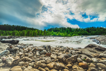 Stunning landscape with white dark cloud and waterfall from uphill in majestic outdoor in northern...