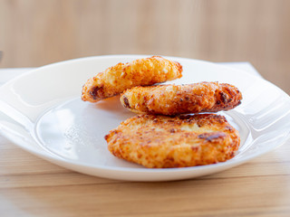 beautiful fried cheesecakes lie on a white plate sprinkled with powdered sugar