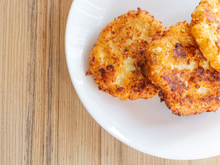 beautiful fried cheesecakes lie on a white plate sprinkled with powdered sugar