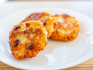 beautiful fried cheesecakes lie on a white plate sprinkled with powdered sugar