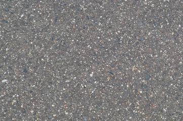 The texture of the background of stone black gray asphalt road with small pebbles