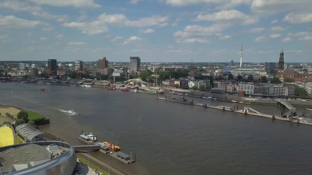 Scenic panorama over the Hamburg Harbor with Landungsbruecken, musical halls, ships and boats on river Elbe, and the TV tower