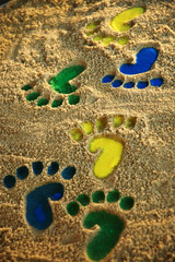 Bunte Fußabdrücke im Sand