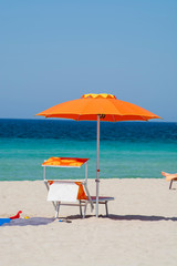Service on beach, colorful sun bed and parasol for rent on beautiful white sandy beach with crystal clear blue sea water