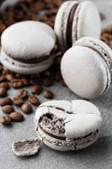 French macaroons isolated with coffee beans. Selective focus. macaroon in gray tone. French crash macarons on gray stone background. Stylish arrangement sweet. Flat lay, top view.