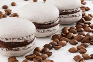 French macaroons isolated with coffee beans. Selective focus. macaroon in gray tone. Beautiful macaroons on marble background. Stylish arrangement sweet. Flat lay, top view.