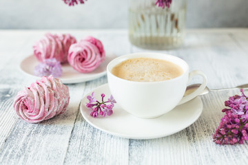 Obraz na płótnie Canvas Bouquet of lilacs, cup of coffee, homemade marshmallow Romantic spring morning Selective focus