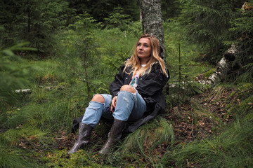 Young pretty woman gets in touch with nature in a forest during moody summer day 