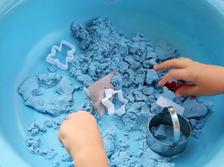 boy plays kinetic sand at home