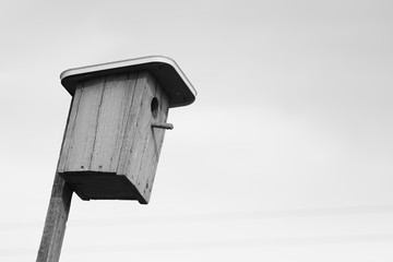Blue wooden homemade birdhouse on the sky background