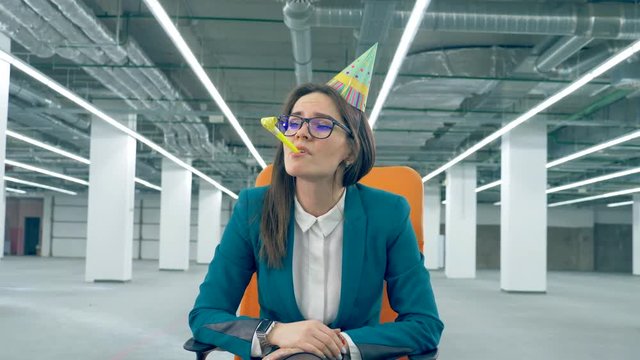 Businesswoman is sadly blowing a party whistle. Boring party concept.