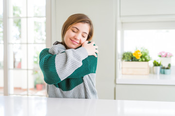 Young beautiful plus size woman wearing casual striped sweater Hugging oneself happy and positive, smiling confident. Self love and self care