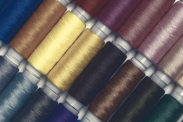 Close up colourful spools of thread. Macro photography fashion tailor background