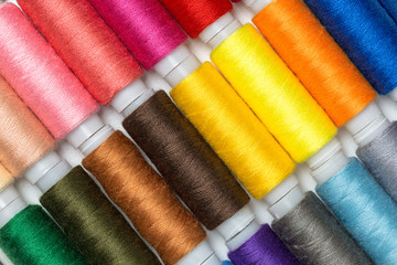 Close up colourful spools of thread. Macro photography fashion tailor background