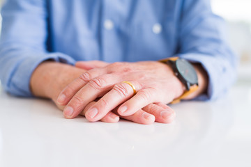 Close up of man hands with hands on each other over white table