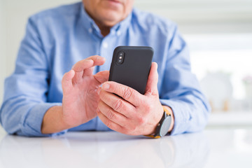 Close up of man hands using smartphone over white table