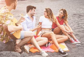Group of young people playing guitar on the beach, youth lifestyle leisure activities concept.