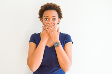 Young beautiful african american woman over white background shocked covering mouth with hands for mistake. Secret concept.
