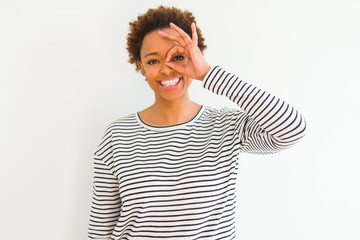 Young beautiful african american woman wearing stripes sweater over white background doing ok gesture with hand smiling, eye looking through fingers with happy face.