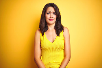 Obraz premium Young beautiful woman wearing t-shirt standing over yellow isolated background depressed and worry for distress, crying angry and afraid. Sad expression.