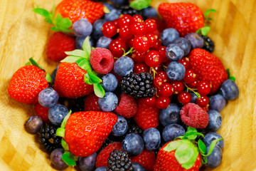 Fototapeta premium assorted fresh berries with wooden background