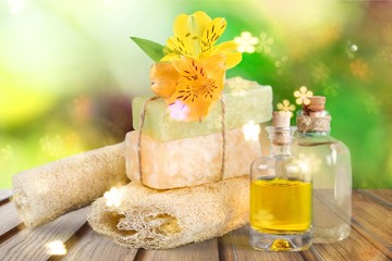 Healthy spa concept with handmade soap bars, oil bottles, sponge and flowers