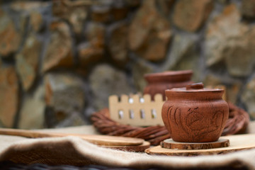 clay pot for honey on a wicker wooden table with a wooden spoon