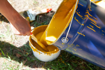 Paint brush. Man paints objects in the yard. Work with color. It's time to upgrade the garden.