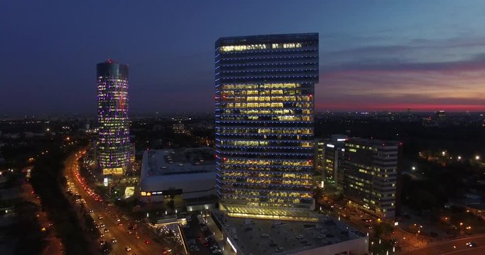 Aerial shot over Bucharest’s northern area. Evening / night shot with gorgeous red sky in a very important area of corporate buildings from Bucharest with tall, glass, modern skyscrapers. 