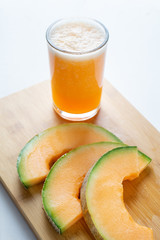 Cantaloupe melon juice and slices on white background