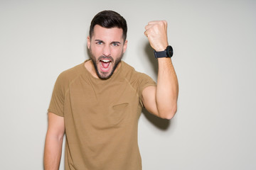 Young handsome man over isolated background annoyed and frustrated shouting with anger, crazy and yelling with raised hand, anger concept