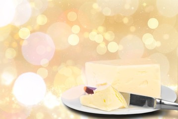 Pat of fresh farm butter on a butter dish with a knife on backgrouund