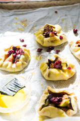 Plum tartelette are lined o cooking paper with egg yellow ready to be put in oven.