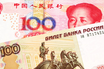 A close up image of a one hundred Russian ruble bank note close up with a red one hundred Chinese yuan bank note