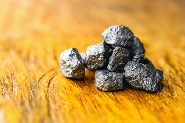 large crude silver gemstone in wooden background, rare silver nugget. Precious stone, luxury...